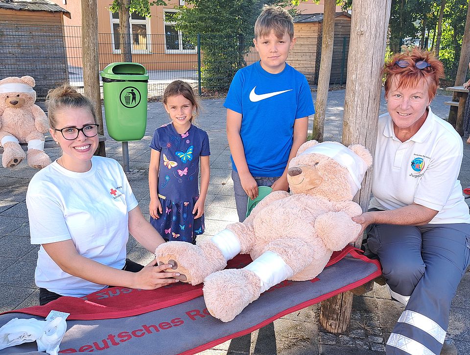 Die Schulsozialarbeiterin der Löwenzahn-Grundschule Velten, Marisa Müller (links) und Ines Sinske vom Jugendrotkreuz Oranienburg haben mit Lara und Max aus der Klasse 2c Plüschtiere aus dem Bärenhospital verbunden.